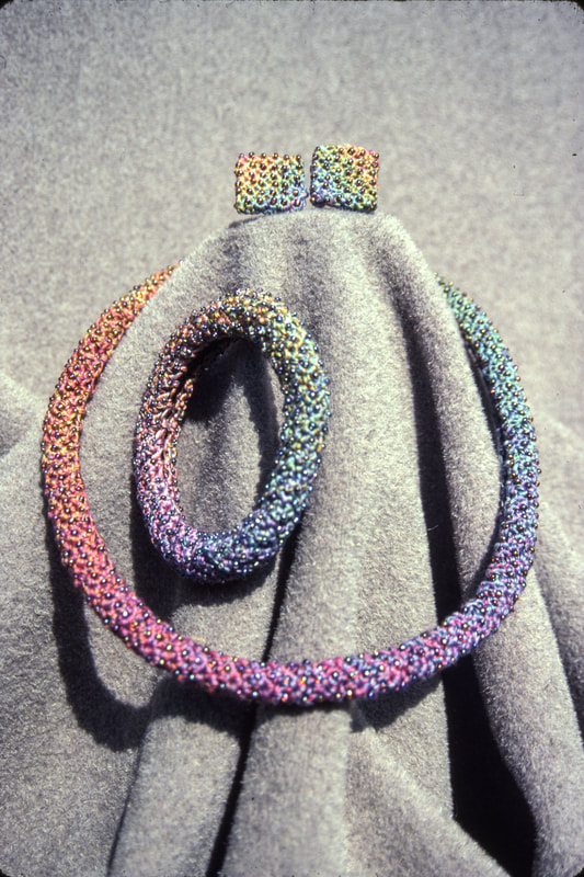 Elizabeth Tuttle, Rainbow Rope Collar Bracelet and Earrings. Crocheted cotton sewing thread with glass beads.