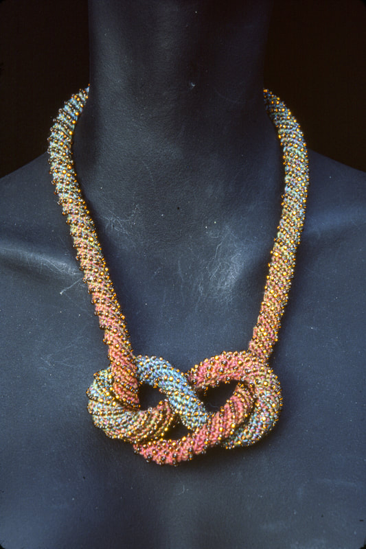 Elizabeth Tuttle, Light Rainbow Rope Collar with Bracelet. Crocheted cotton sewing thread with glass beads.